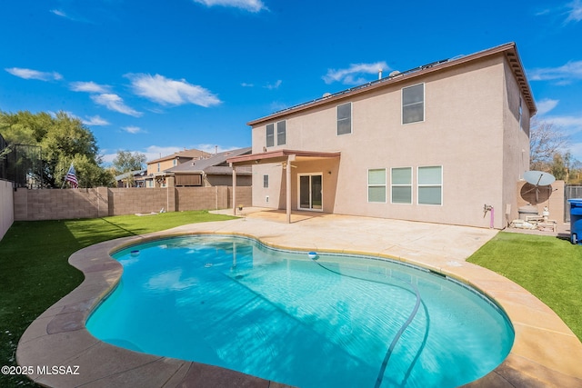 rear view of house featuring a fenced in pool, a fenced backyard, a yard, a patio area, and stucco siding