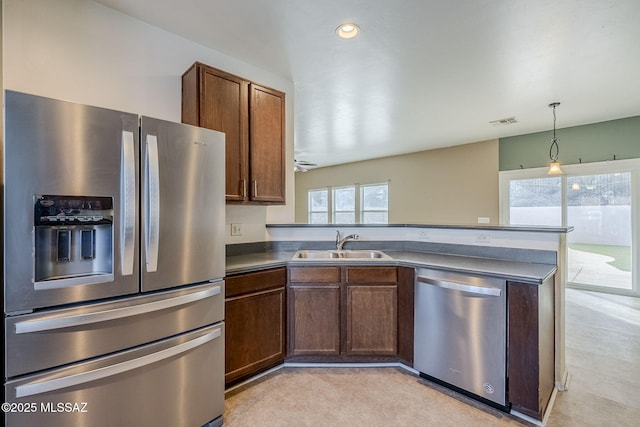 kitchen with kitchen peninsula, stainless steel appliances, ceiling fan, sink, and hanging light fixtures