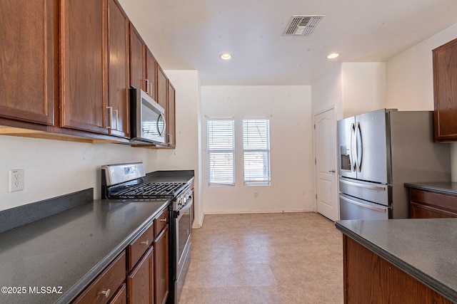 kitchen featuring light floors, dark countertops, visible vents, appliances with stainless steel finishes, and brown cabinetry