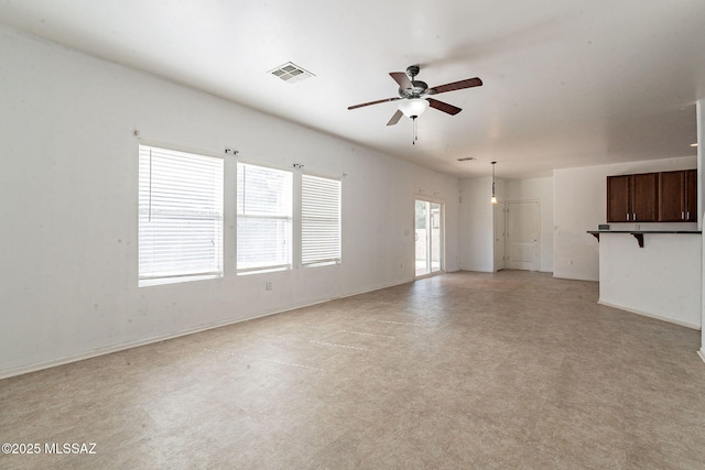 unfurnished living room with ceiling fan, visible vents, and baseboards