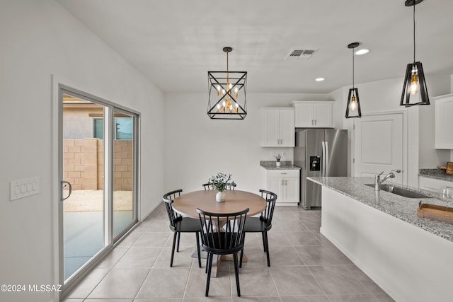 dining area with a wealth of natural light, sink, and light tile patterned flooring