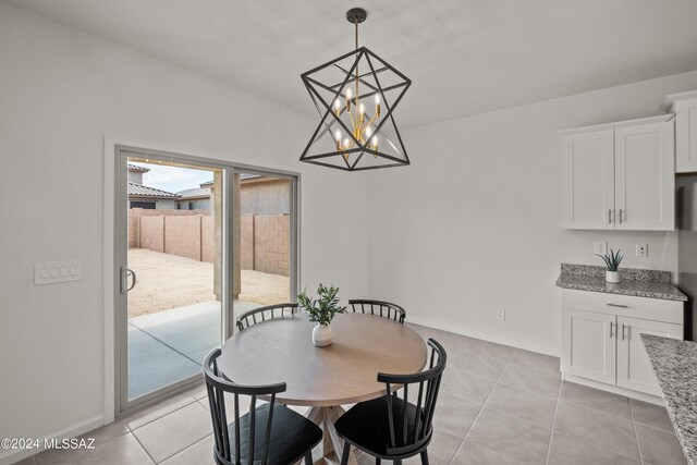 dining area with a chandelier and light tile patterned flooring