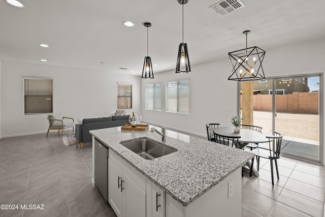 kitchen featuring light tile patterned floors, a wealth of natural light, sink, and a center island with sink