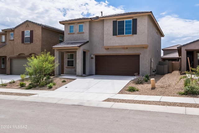 view of front of home with a garage, concrete driveway, and stucco siding