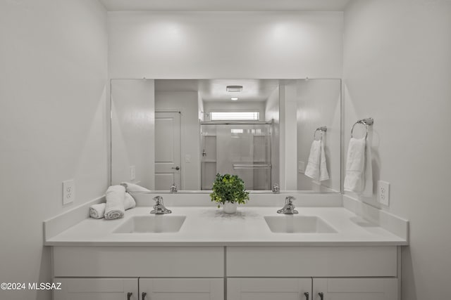 bathroom featuring vanity and a shower with door