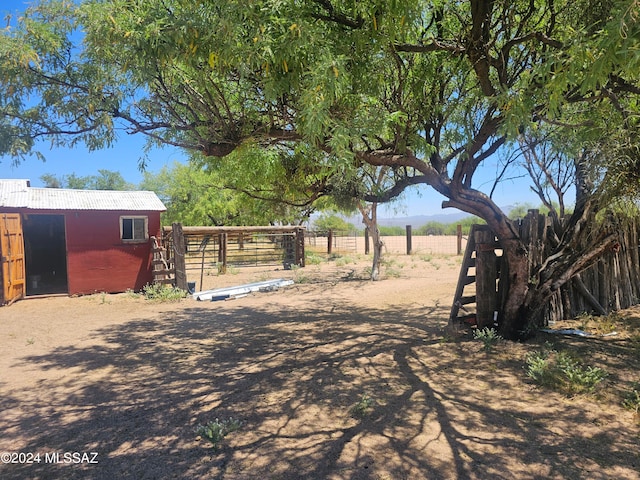 view of yard featuring a rural view and an outbuilding