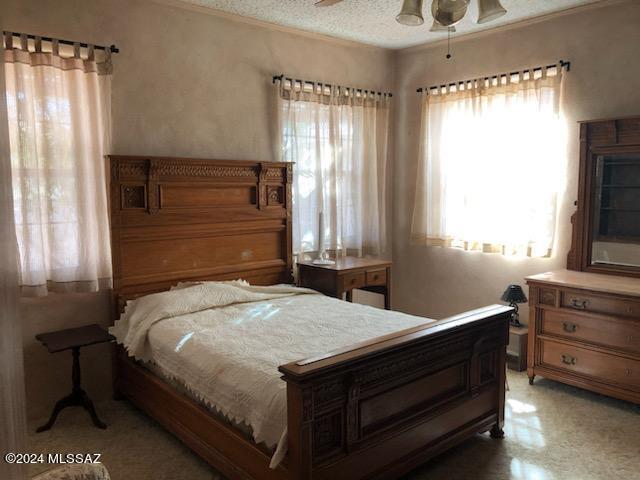 bedroom with ceiling fan and a textured ceiling