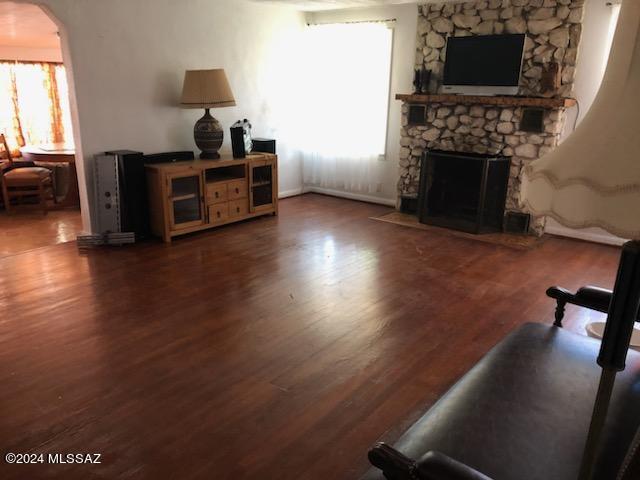 living room featuring a fireplace and dark wood-type flooring