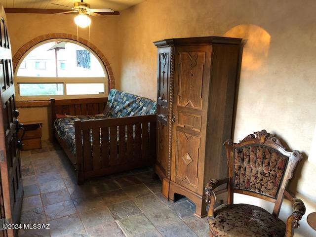 tiled bedroom featuring ceiling fan