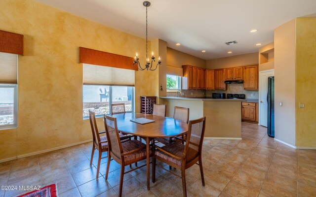 tiled dining space with a notable chandelier