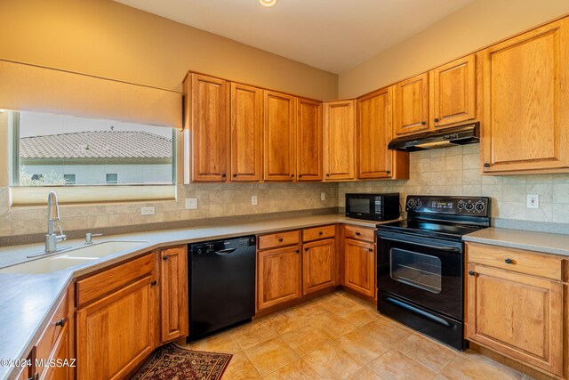 kitchen featuring black appliances, sink, and backsplash