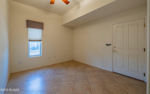 unfurnished room with baseboards, a ceiling fan, and light tile patterned flooring