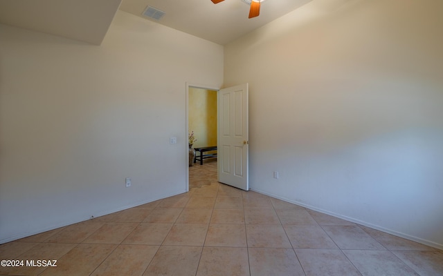 spare room featuring a ceiling fan, visible vents, and light tile patterned floors