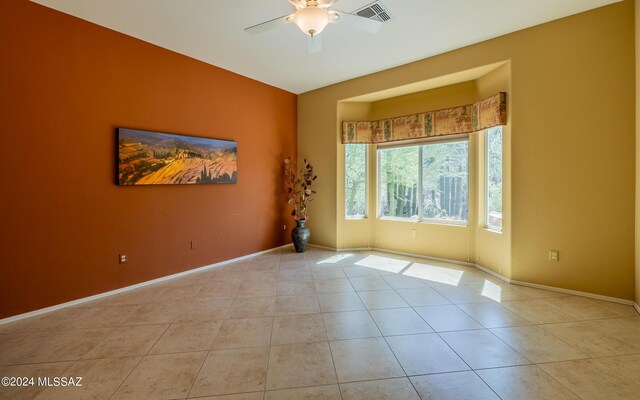 tiled empty room featuring ceiling fan