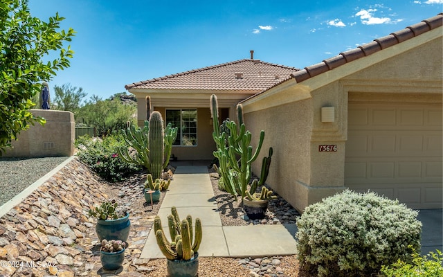 view of front of house with a garage, a tile roof, and stucco siding