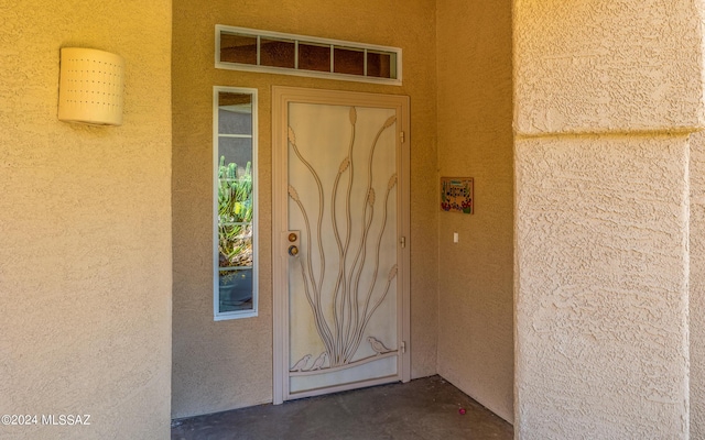 doorway to property featuring visible vents and stucco siding