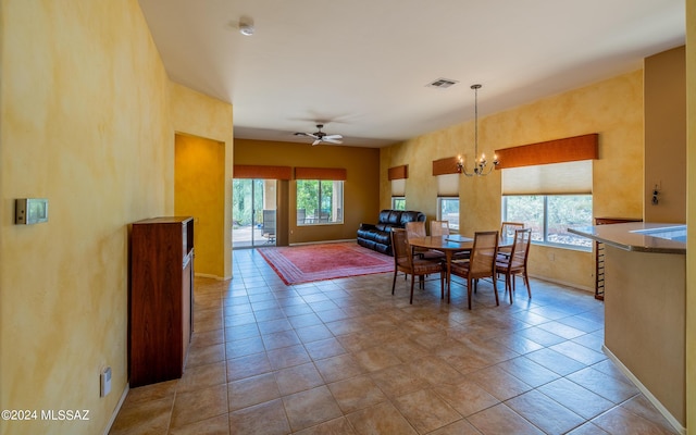 dining area with ceiling fan with notable chandelier, plenty of natural light, visible vents, and baseboards