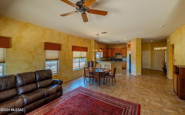 living room featuring recessed lighting, baseboards, visible vents, and ceiling fan with notable chandelier