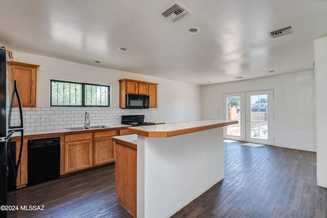 kitchen with dark hardwood / wood-style flooring, black appliances, tasteful backsplash, tile counters, and sink