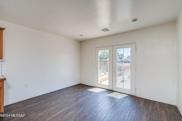 empty room with dark hardwood / wood-style floors and french doors