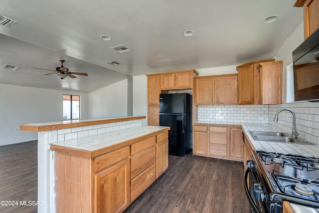 kitchen with tasteful backsplash, black appliances, dark hardwood / wood-style flooring, a kitchen island, and sink