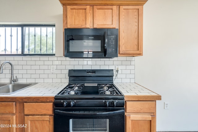 kitchen featuring black appliances, sink, tile countertops, and decorative backsplash