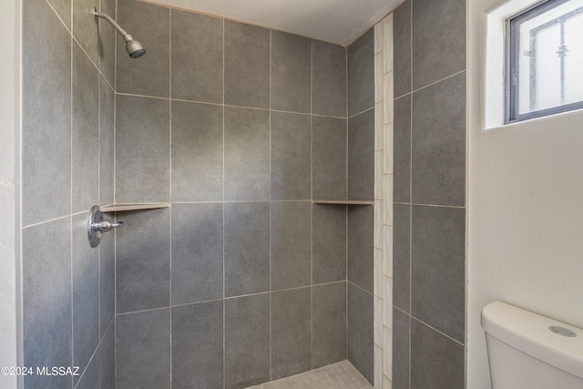 bathroom with tiled shower and toilet