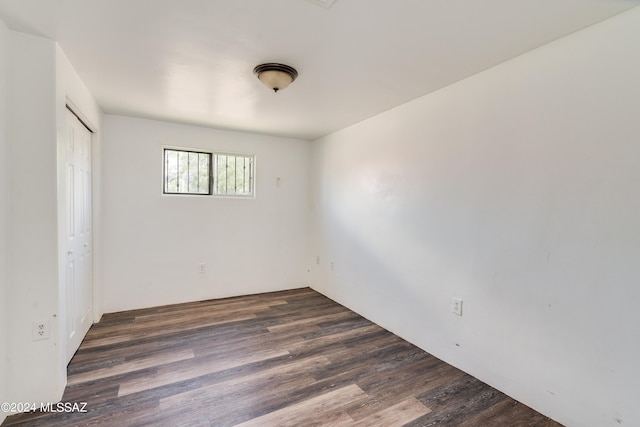 unfurnished room with dark wood-type flooring