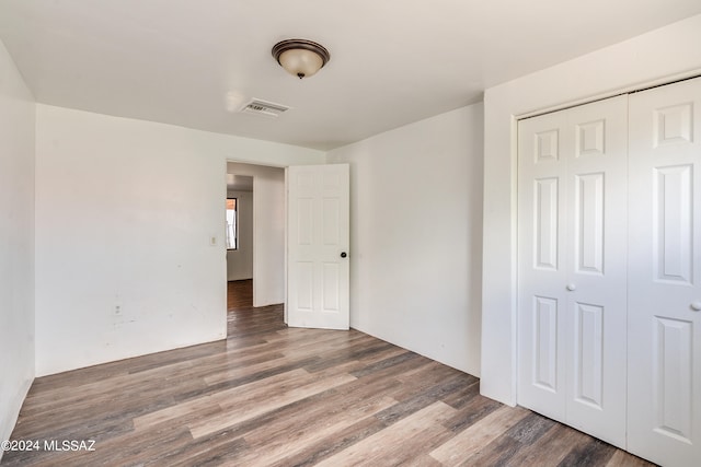 unfurnished bedroom featuring dark wood-type flooring and a closet