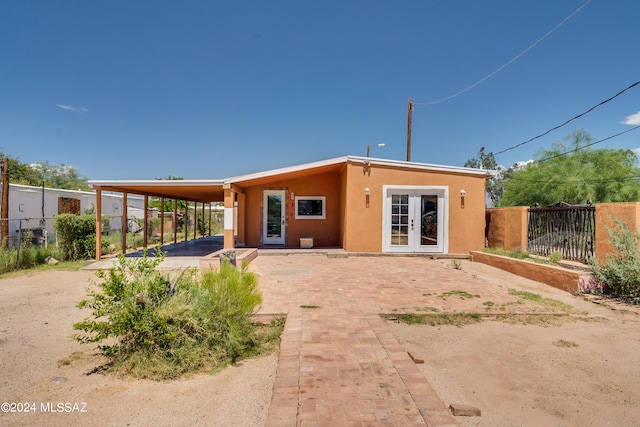 back of house with french doors and a carport