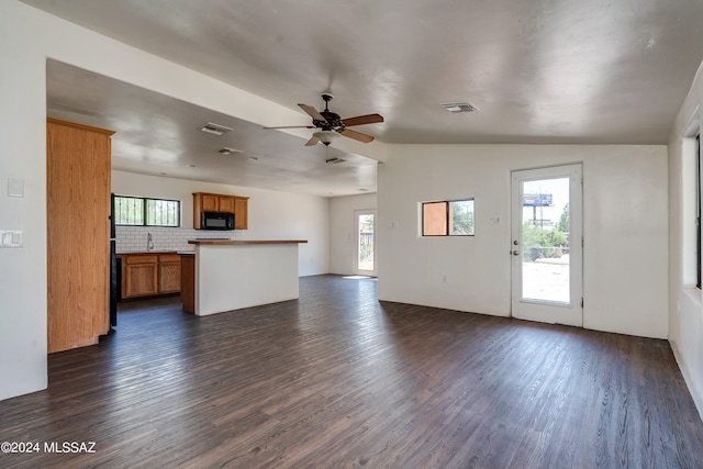 unfurnished living room featuring lofted ceiling, ceiling fan, and dark hardwood / wood-style floors