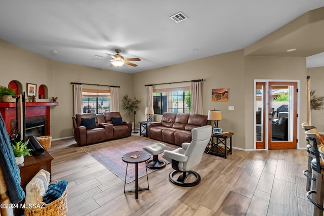 living room with light hardwood / wood-style flooring and ceiling fan