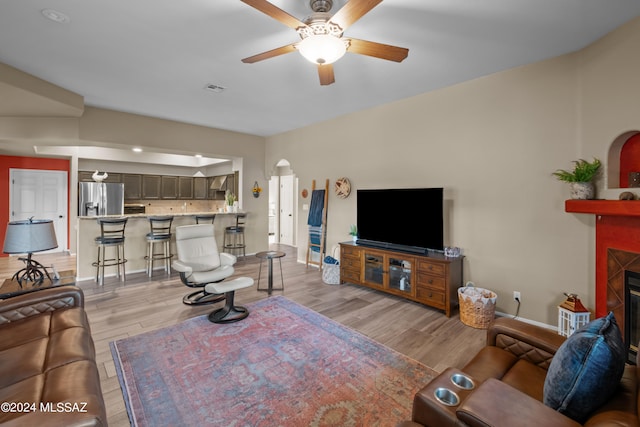 living room with light hardwood / wood-style flooring and ceiling fan