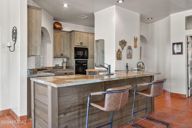 kitchen with light stone counters, black appliances, light brown cabinetry, crown molding, and tile patterned flooring