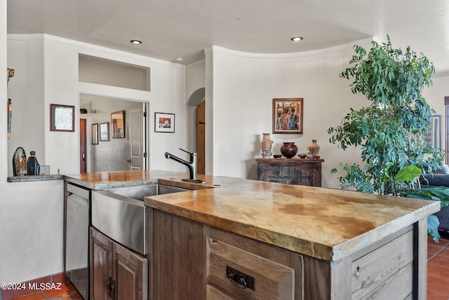 kitchen with ornamental molding, dark tile patterned flooring, sink, and a textured ceiling