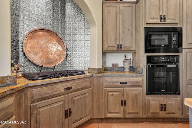 kitchen featuring light tile patterned flooring and black appliances