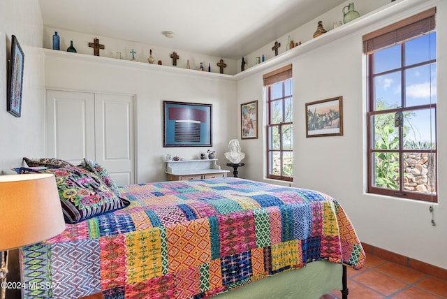 bedroom with a closet, tile patterned floors, and multiple windows