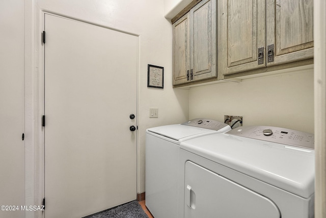 laundry room with washer and clothes dryer and cabinets