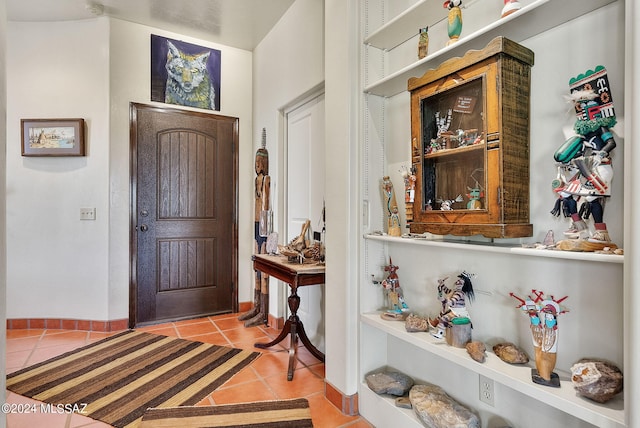 entryway with baseboards and light tile patterned floors