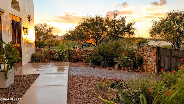 yard at dusk featuring a patio area