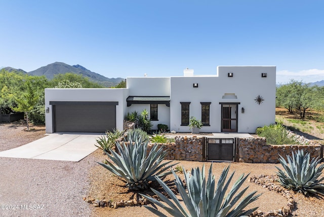 southwest-style home with a garage and a mountain view