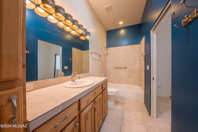 full bathroom with tile patterned flooring, tiled shower / bath combo, vanity, and toilet