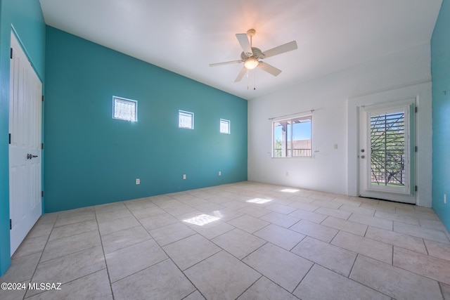 tiled spare room with ceiling fan