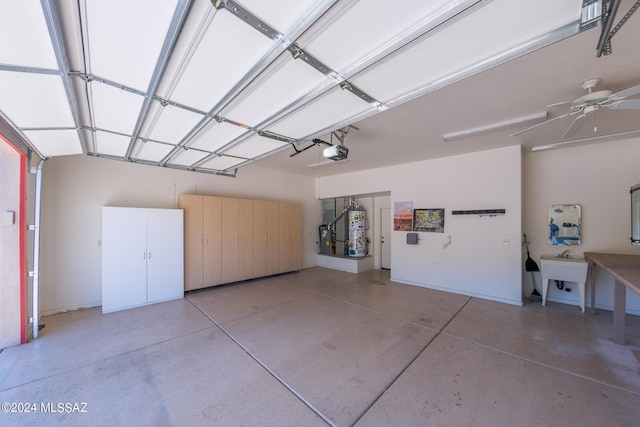 garage with a garage door opener, gas water heater, sink, and ceiling fan