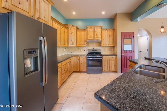 kitchen with sink, tasteful backsplash, decorative light fixtures, appliances with stainless steel finishes, and light brown cabinetry