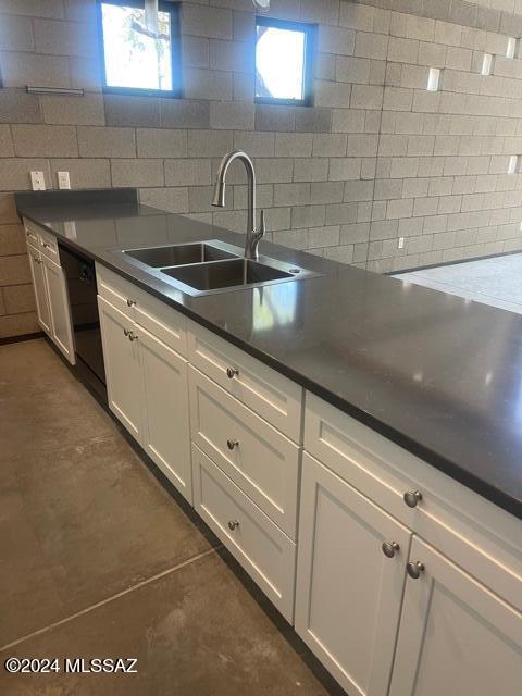 kitchen featuring backsplash, white cabinets, a healthy amount of sunlight, and sink