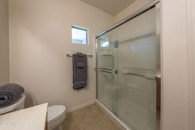 full bathroom with a stall shower, tile patterned flooring, toilet, and baseboards