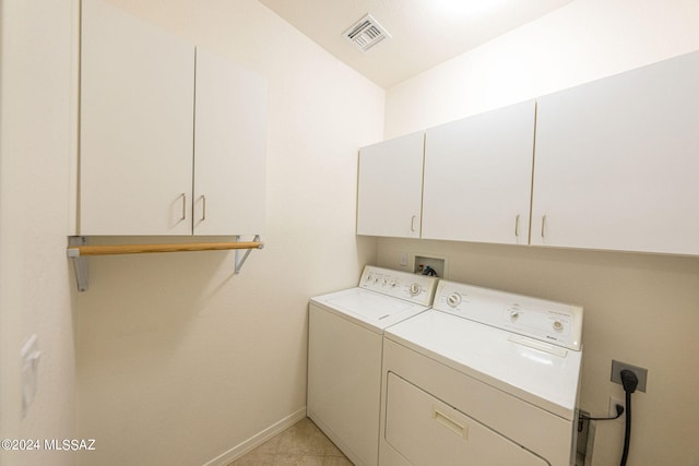 washroom featuring cabinets, washer and clothes dryer, and light tile patterned floors