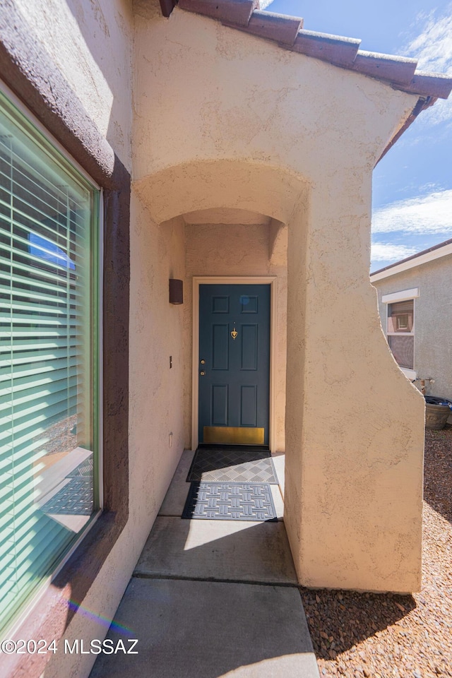 view of exterior entry with stucco siding