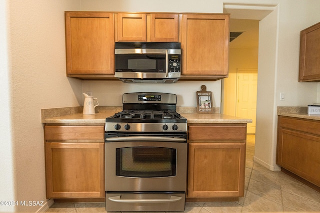 kitchen with appliances with stainless steel finishes and light tile patterned floors